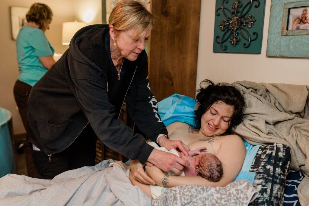 a st. george midwife checks on the newly born baby and mother